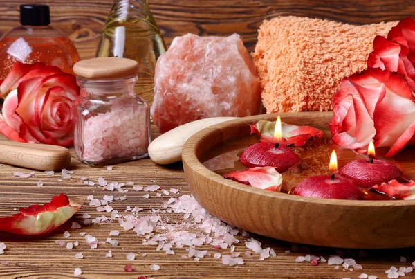 Gül, pembe tuz ve su içinde yüzen mumlar Spa konseptiyle — Stok fotoğraf