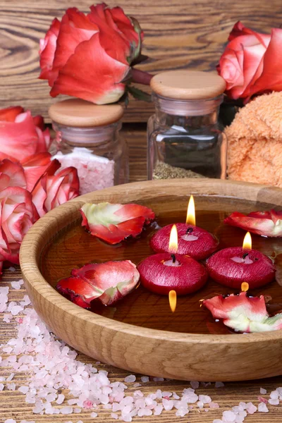 Concept de spa avec des roses, du sel rose et des bougies qui flottent dans l'eau — Photo