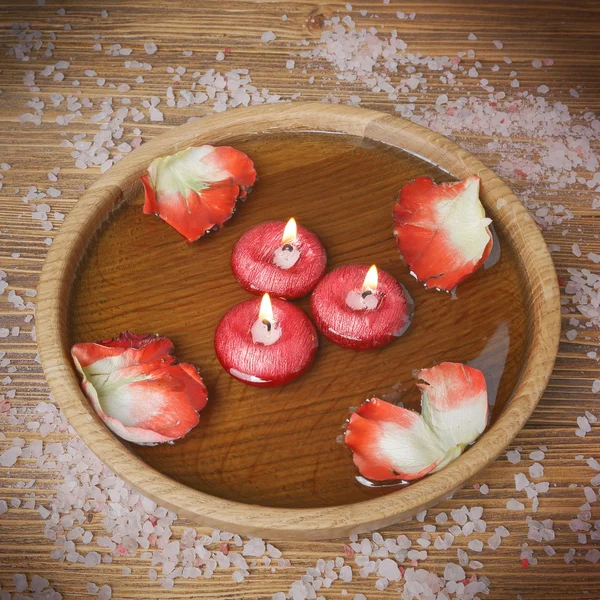 Концепция спа с лепестками роз, солью и горящими свечами — стоковое фото