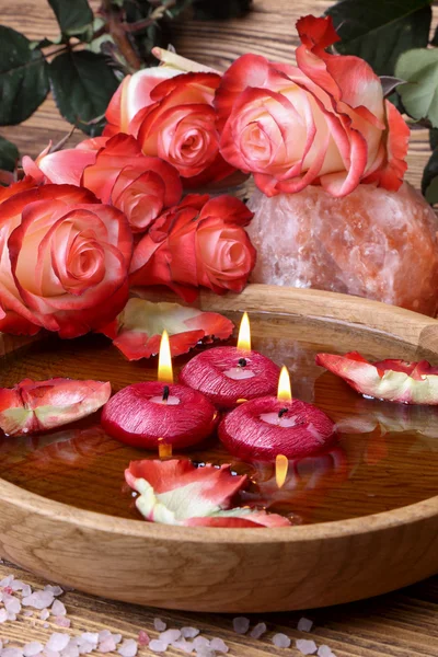 Wellness-Konzept mit Rosen, rosa Salz und Kerzen, die im Wasser schweben — Stockfoto