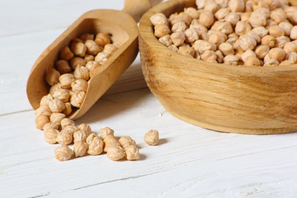 Kikkererwten op een witte houten tafel, close-up — Stockfoto