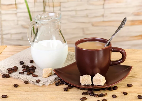 Filiżankę kawy ze śmietaną i dzbanek krem na drewnianym stołem — Zdjęcie stockowe