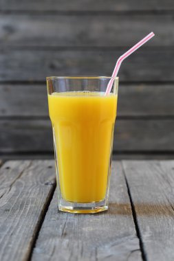Tahta masada bir bardak portakal suyu.