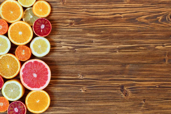 Frutas cítricas cortadas ao meio - laranjas, limões, tangerinas, toranja — Fotografia de Stock