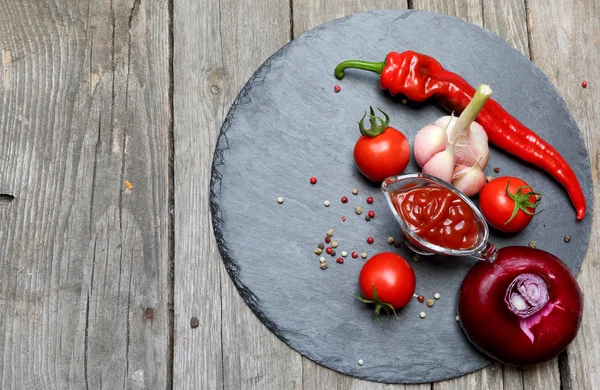 Ketchup-Chili in einem Glas Soße Boot und seine Zutaten auf einem bla — Stockfoto