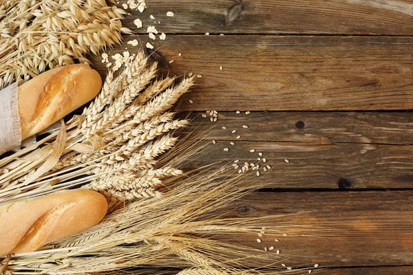 Pão e três tipos de cereais - trigo, centeio e aveia em uma madeira — Fotografia de Stock