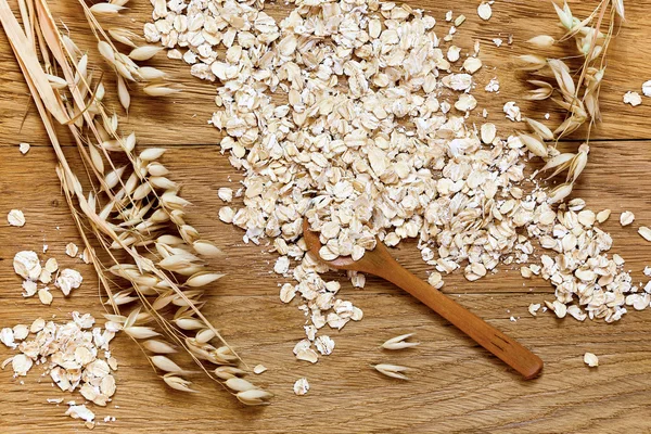 Avena laminata e spighe di avena su un tavolo di legno — Foto Stock