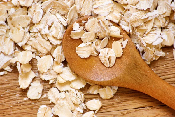Rolde haver en haver oren van graan op een houten tafel — Stockfoto