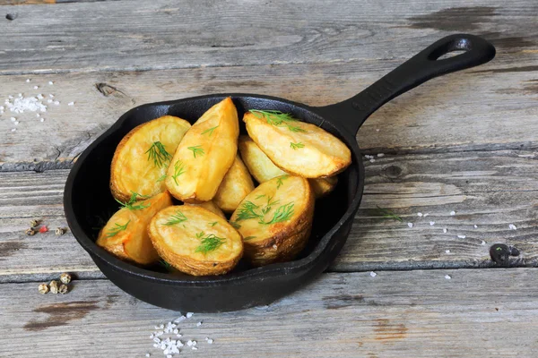 Baked potatoes with dill in village in a cast iron frying pan — Stock Photo, Image