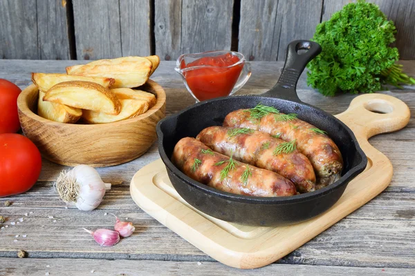 Salsichas de carne grelhadas e batatas em uma panela — Fotografia de Stock