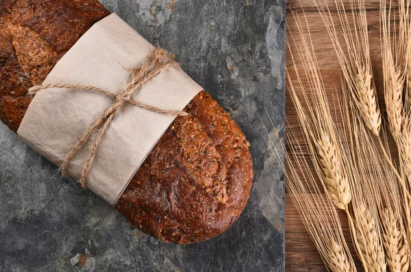 Vícezrnné pečivo a stébla pšenice — Stock fotografie