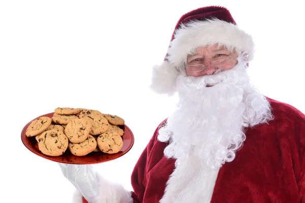 圣诞老人手里拿着一大盘红色的新鲜烤巧克力曲奇饼 用白色隔开 — 图库照片