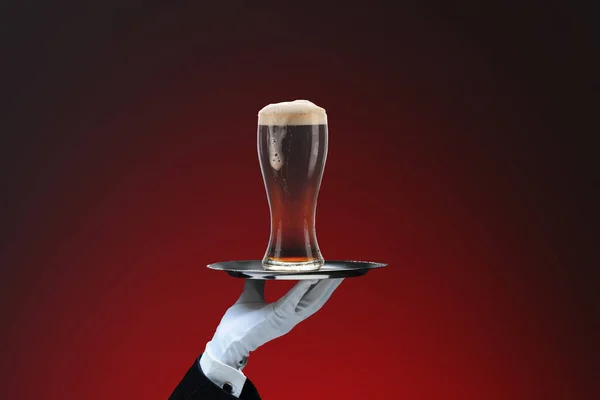 Bir Garsonun Eli Köpüklü Bir Bardak Koyu Birayla Kırmızı Benekli — Stok fotoğraf