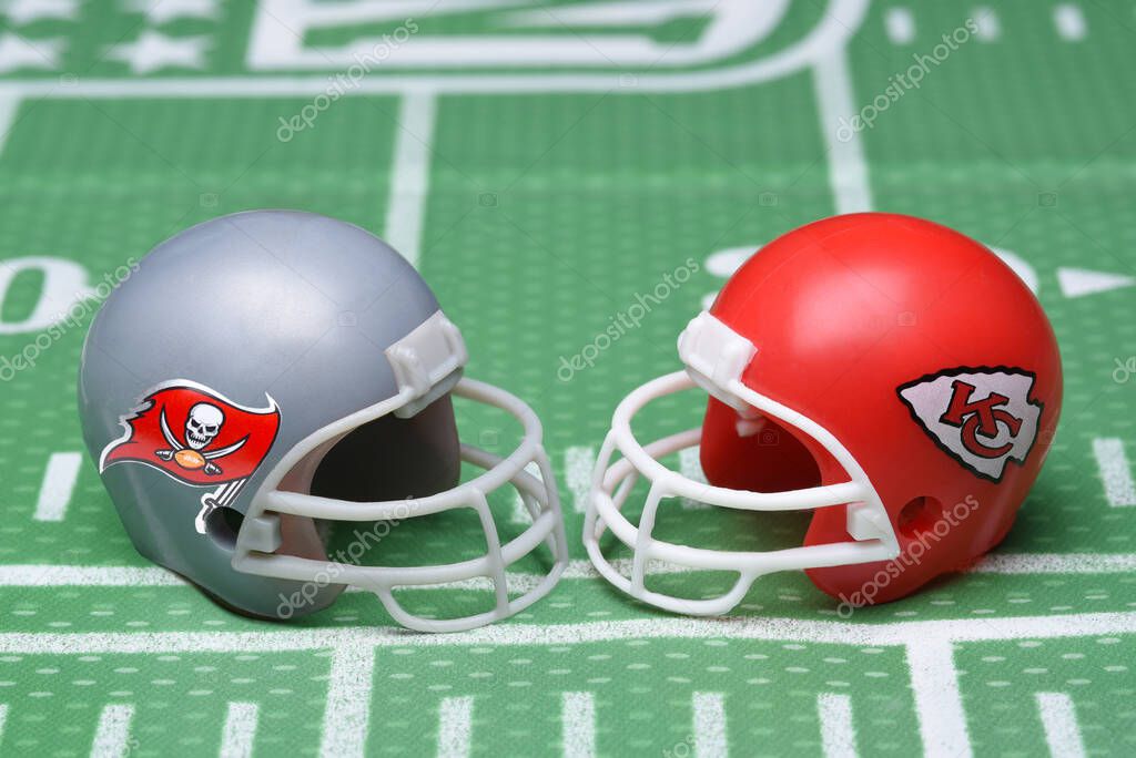 IRVINE, CALIFORNIA - 25 JAN 2021: Helmets for the Tampa Bay Buccaneers, and Kansas City Chiefs, opponents in Super Bowl LV. on a green football field background.