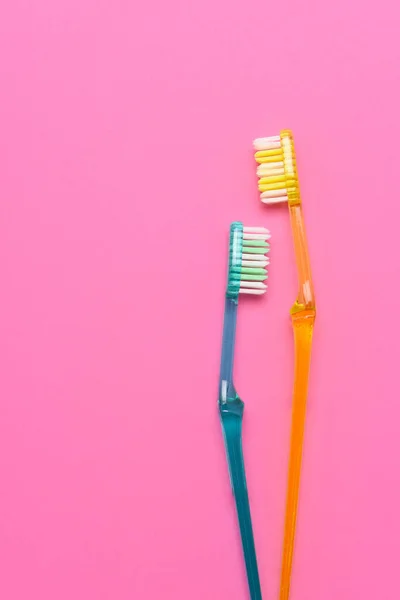 粉红和蓝色背景上的两个牙刷 具有复制空间的片状高角度视图 — 图库照片