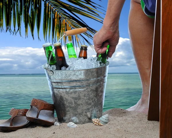 Uomo con secchio di birra in spiaggia — Foto Stock