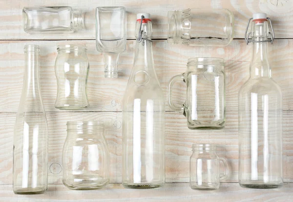 Assorted Clear Glass Bottles on White Wood — Stock Photo, Image