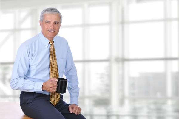 Mature Busimessman Sitting on Desk — Stock Photo, Image