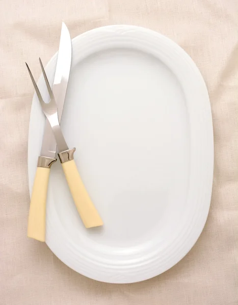 Резьба ножа и вилки на блюдечке — стоковое фото