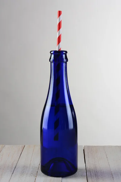 Blue Bottle with Red Striped Straw — стокове фото