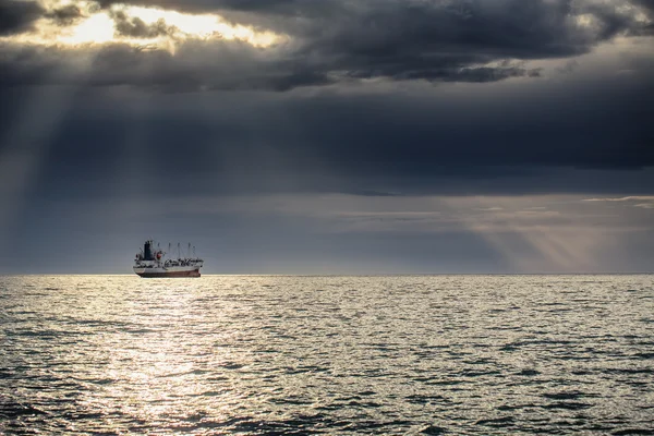 Frachtschiff fährt bei Sonnenaufgang in Strandnähe — Stockfoto