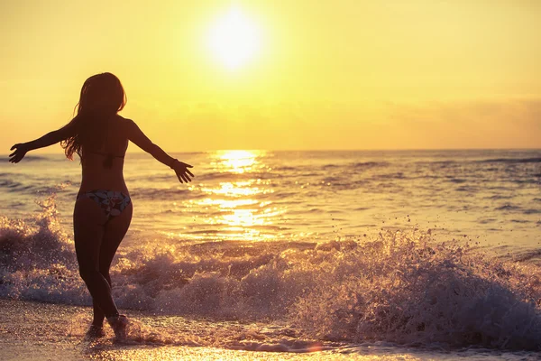 Sahilde kaygısız kadın silüeti