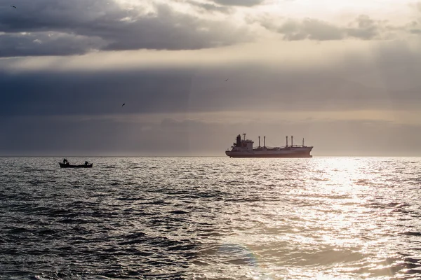 Frachtschiff fährt bei Sonnenaufgang in Strandnähe — Stockfoto