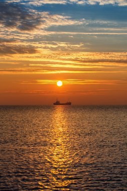 Sunrise, plaja yakın yelken kargo gemisi