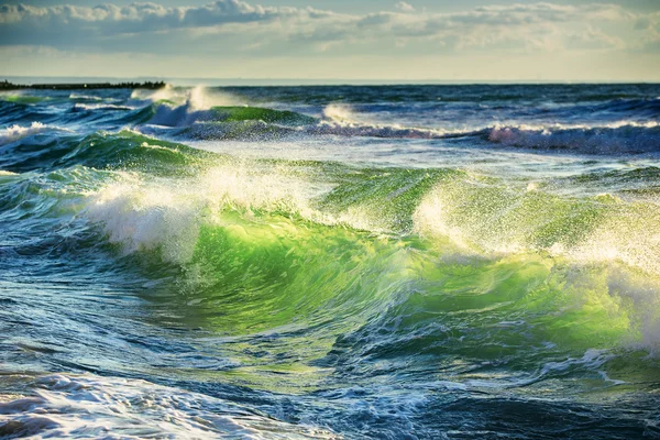 Východ slunce a zářivé vlny v oceánu — Stock fotografie