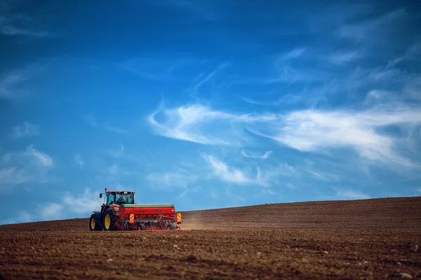 Landwirt mit Traktor sät Getreide auf Feld — Stockfoto