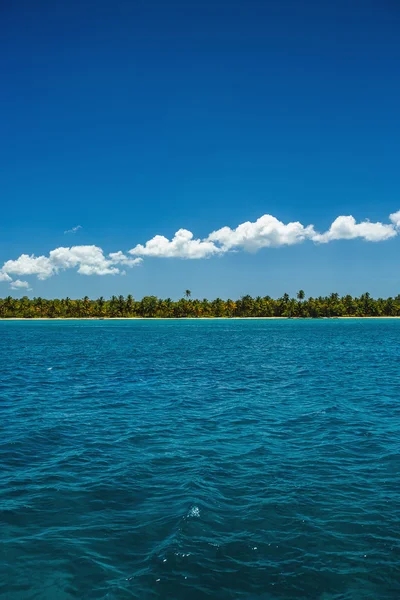 Nuvens fofas brancas céu azul acima de uma superfície do mar — Fotografia de Stock