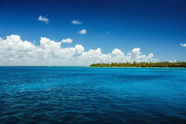 海の表面上に白いふわふわ雲の青い空 — ストック写真