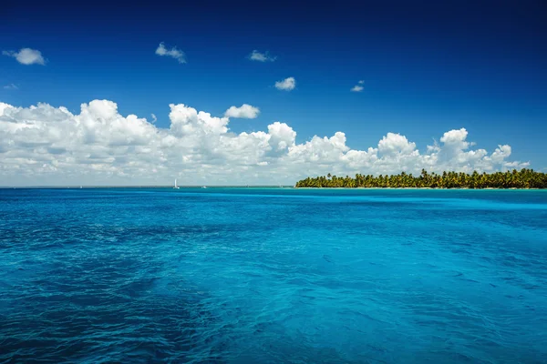 Nuvens fofas brancas céu azul acima de uma superfície do mar — Fotografia de Stock