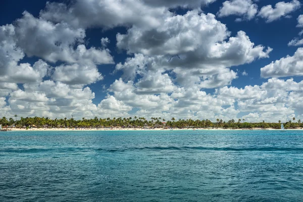 White fluffy clouds blue sky above a surface of the sea — Stock Photo, Image