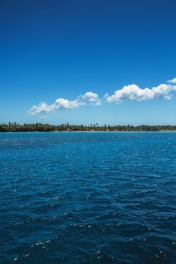 kabarık beyaz bulutlar deniz yüzeyinin üzerinde mavi gökyüzü