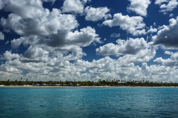 Witte pluizige wolken blauwe hemel boven een oppervlakte van de zee — Stockfoto