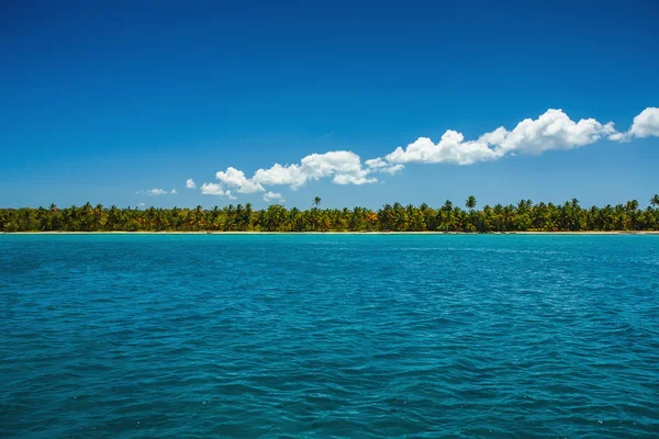 Nuvens fofas brancas céu azul acima de uma superfície do mar — Fotografia de Stock