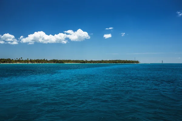 Nuvens fofas brancas céu azul acima de uma superfície do mar — Fotografia de Stock