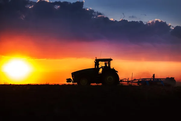 Rolnik w ciągniku przygotowuje grunty z kultywatorem nasiennym — Zdjęcie stockowe