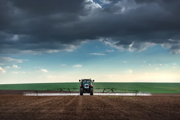 Plantação de tratores agrícolas e pulverização no campo — Fotografia de Stock