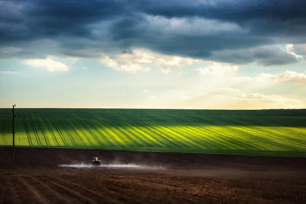 Сільськогосподарський трактор оранки та обприскування на полі — стокове фото