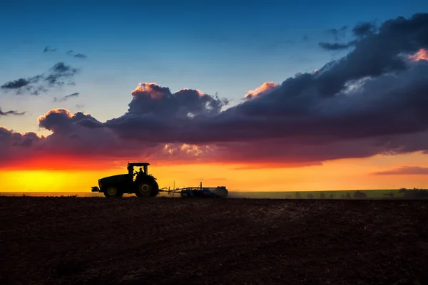 Farmář v traktoru připravuje půdu s kultivátorem seťového lůžka — Stock fotografie