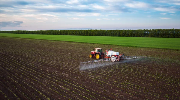 Agricultura tractor pulverización en el campo en primavera — Foto de Stock