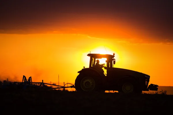 Jordbrukare i traktor förbereder mark med såbäddskultivator — Stockfoto