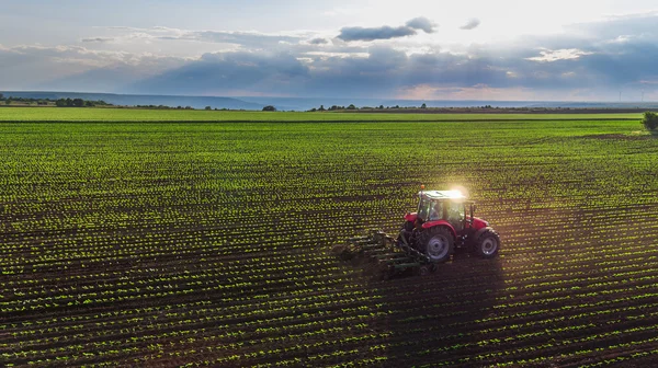 Campo de cultivo de tratores na primavera — Fotografia de Stock