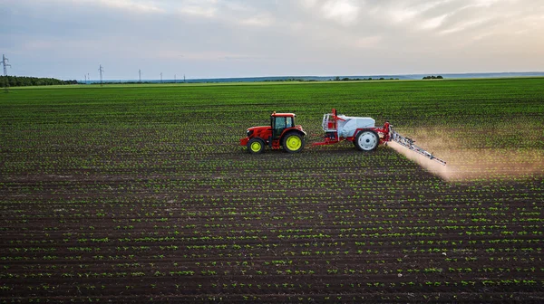 Traktor bespruta fältet på våren — Stockfoto
