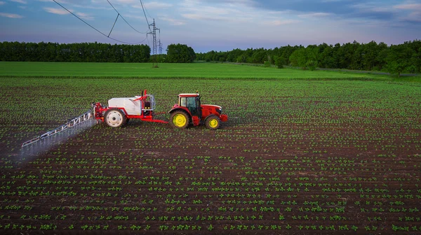 Traktor sprüht Feld im Frühling — Stockfoto