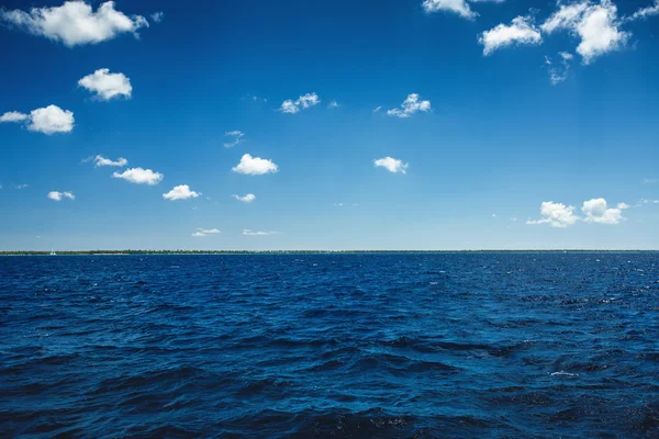 以上的海洋表面的白色蓬松的云彩蓝色天空 — 图库照片
