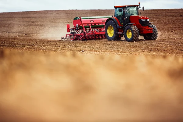 Agricultor con cultivos de siembra de tractor en el campo — Foto de Stock