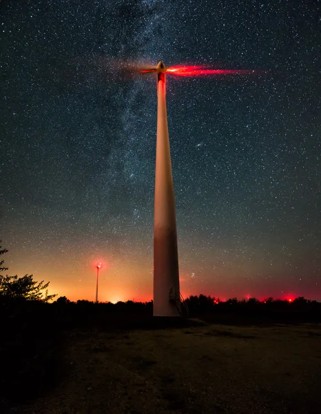 Ветряные турбины на звездном ночном небе с молочной дорожкой Стоковое Изображение